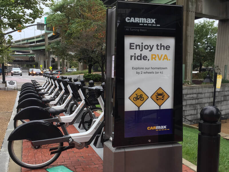RVA Bikeshare station poster outside a CarMax office location.